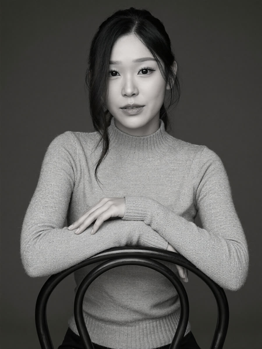 Look 5: black-and-white portrait in a ribbed turtleneck, arms resting on a backward metal chair