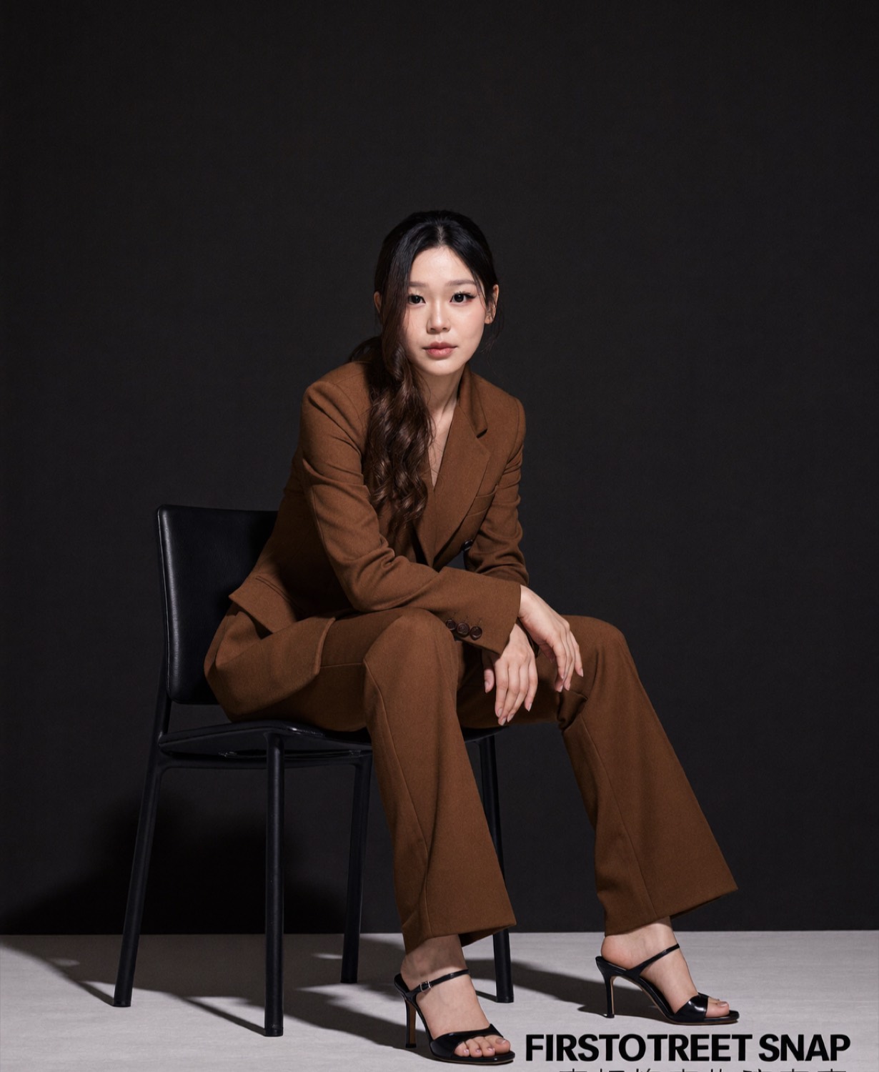 Cindy's generated portrait: Tobacco brown suit on the black chair