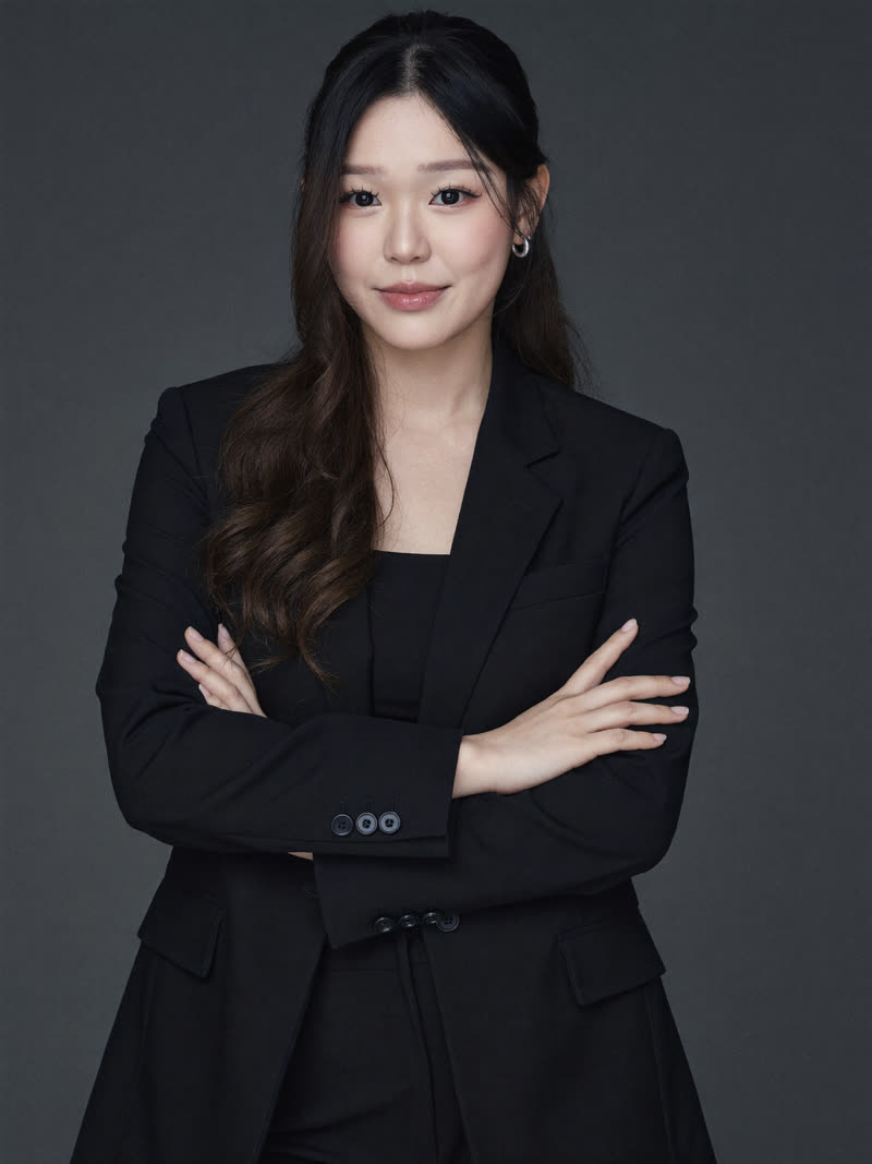 AI LinkedIn headshot: black suit with arms crossed on a grey seamless backdrop